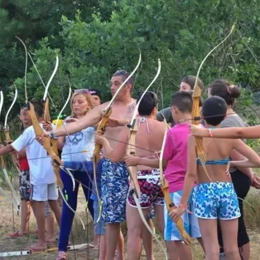 Enfants et adultes pratiquant l'archerie au Camping Des Pins