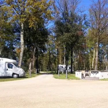 Campeurs avec camping-car dans une zone arborée au Camping du Port Mulon