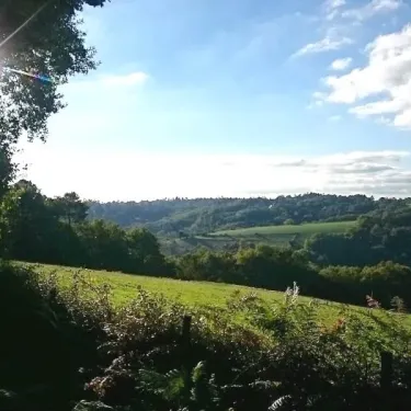 Ville de campagne avec collines verdoyantes sous un ciel bleu