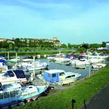 Camping L'Ile du Rhin : quai avec bateaux amarrés sur un fleuve