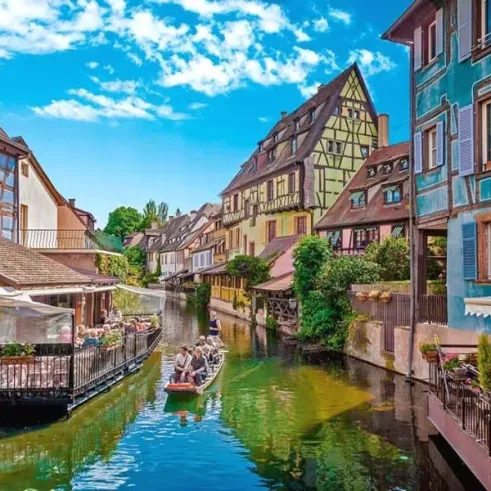 Ville de Colmar avec canoë sur le canal, façades colorées et toits en bois
