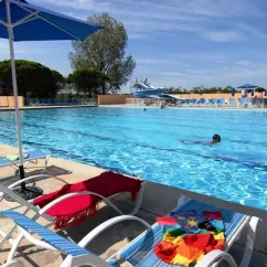 Piscine avec chaises longues et parasol au Camping Port Camargue