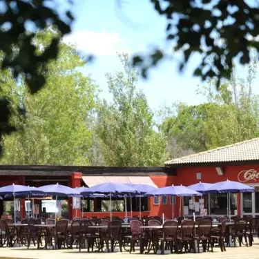 Terrasse extérieure du Café Soleil avec parasols et chaises autour d'un restaurant
