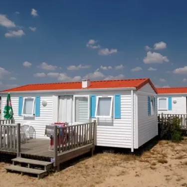 Camping L'Etang de Besse : rangées de mobil-homes blancs avec toit rouge sous un ciel bleu