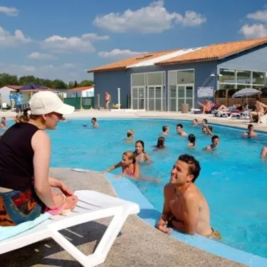 Personnes autour d'une piscine extérieure au Camping L'Etang de Besse