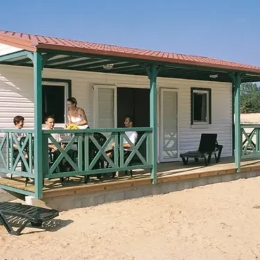 Camping L'Etang de Besse : mobil-home avec balcon et chaises longues sur plage