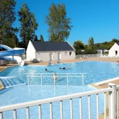 Piscine avec toboggan et personnes nageant au Camping Kerarno
