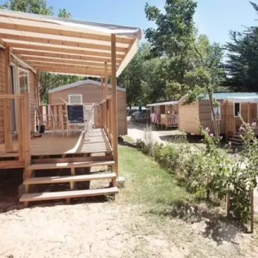 Camping Les Demoiselles : mobil-home avec véranda et escaliers en bois