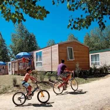 Enfants à vélo devant mobil-home au Camping Les Demoiselles