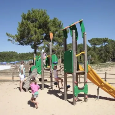 Enfants qui jouent sur un parc de jeux en bois au Camping Les Demoiselles