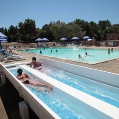 Personne glissant dans une chute d'eau à la piscine du Camping Les Demoiselles