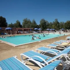 Lits de soleil bleus autour d'une piscine au Camping Les Demoiselles