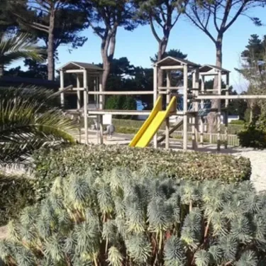 Piste de jeux en bois avec toboggan jaune au Camping Port de la Chaine