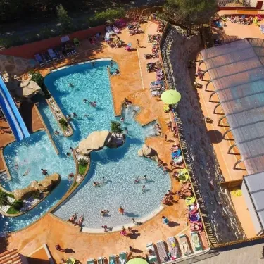 Vue aérienne de la piscine avec toboggan et zones de détente au Camping Les Albères