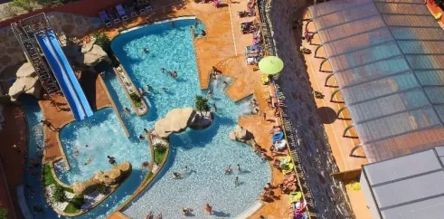 Vue aérienne de la piscine avec toboggan et zones de détente au Camping Les Albères