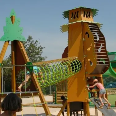 Enfants jouant sur une aire de jeux en bois au camping Les Albères