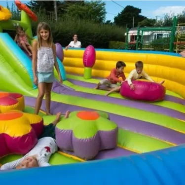 Enfants sur un parcours d'inflation coloré au Camping Les Iles