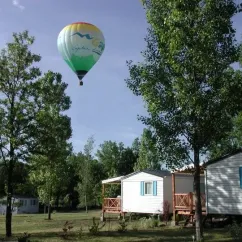 Ballon chaud au-dessus des cabanes du Camping Les Bonnets