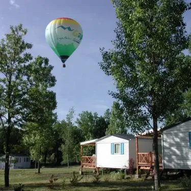 Ballon chaud au-dessus des cabanes du Camping Les Bonnets