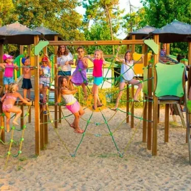 Enfants jouant sur un parc d'attractions en bois au Camping Zagarella