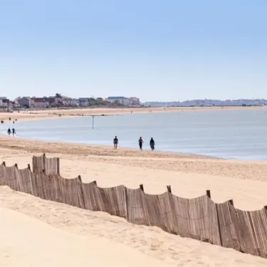 Plage avec clôture en bois et visiteurs près de l'eau au Camping Village Corsaire