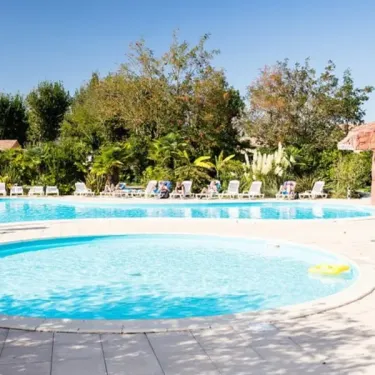 Piscine avec une zone circulaire et des chaises longues autour, Camping Village Corsaire