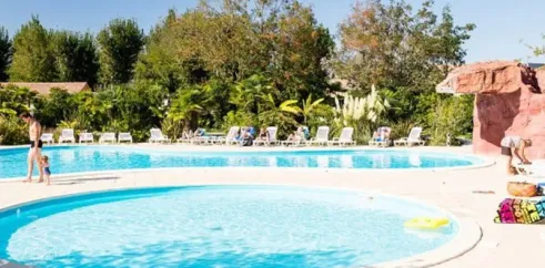 Piscine avec une zone circulaire et des chaises longues autour, Camping Village Corsaire