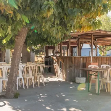 Terrasse ombrée avec tables et chaises au Camping Le Lamparo