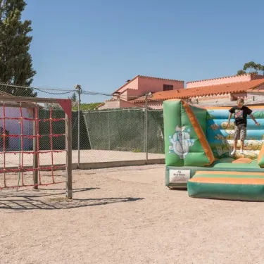 Enfant sur un parcours gonflable au Camping Le Lamparo