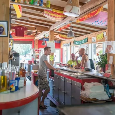 Photo Camping Le Lamparo : bar avec clients et décor coloré