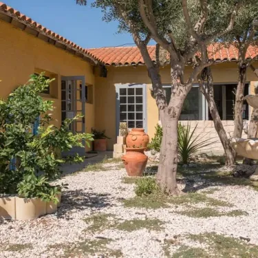 Photo Camping Le Lamparo : jardin avec maison jaune et arbres