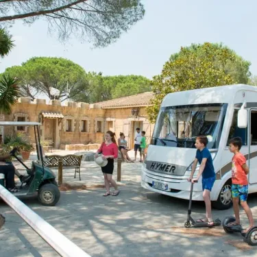 Camping Domaine de Verdagne : camping-car Hymer et enfants avec scooter.