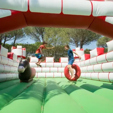 Enfants jouent sur un parcours gonflable dans le camping.