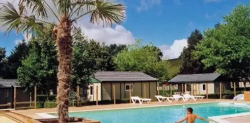 Piscine entourée de mobil-homes au Camping Hameau Saint Martial