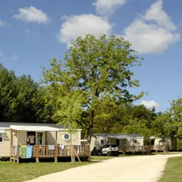 Camping Les Ondines avec mobil-homes et arbres sous un ciel bleu