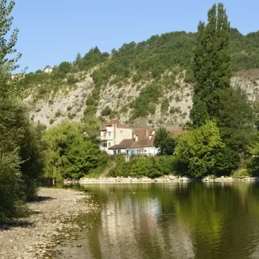 Rivière paisible avec falaise et maison au bord de l'eau