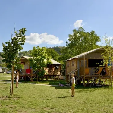 Camping Les Ondines : mobil-homes en bois avec enfants sur pelouse