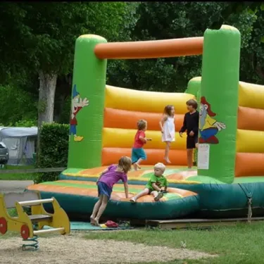 Enfants jouent sur un manège gonflable au Camping Les Ondines