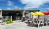 Camping Borepo : terrasse avec parasols jaune et rouge et chaises blanches