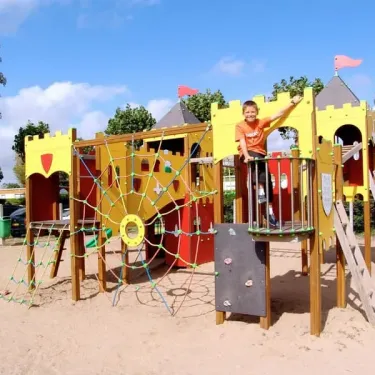 Enfant sur un manège de type château au Camping La Plage