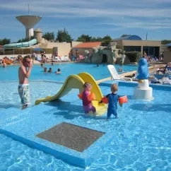 Enfants dans une piscine avec toboggan au Camping La Plage