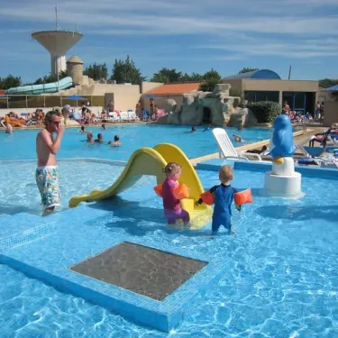 Enfants dans une piscine avec toboggan au Camping La Plage