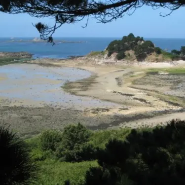 Vue panoramique d'un paysage côtier avec des îlots rocheux et une plage exposée
