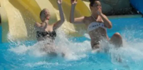 Deux femmes s'amusent dans une chute d'eau à l'aquapark du Camping Du Kérou