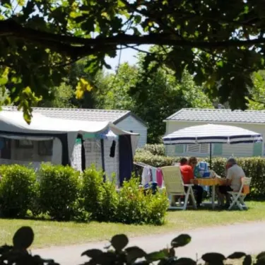Personnes déjeunant à table sous un arbre au Camping Du Kérou