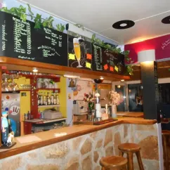 Bar du Camping Du Kérou avec menu sur tableau noir et décor végétal