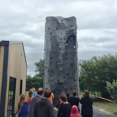 Enfant grimpe sur mur d'escalade au Camping Du Golf