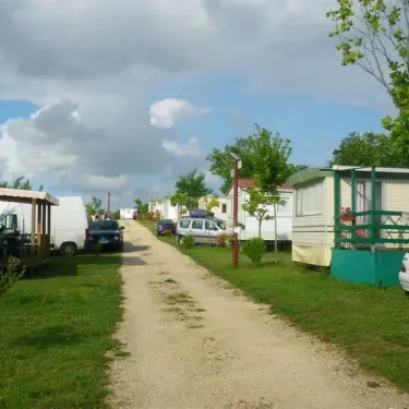 Camping Le Pontis avec mobil-homes et voitures sur une route en gravier