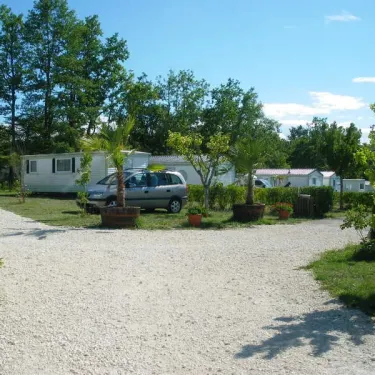 Camping Le Pontis avec mobil-homes entourés d'arbres et de plantes en pot