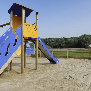 Piste de jeux en bois avec toboggan et escaliers bleus au Camping Domaine De La Roselière